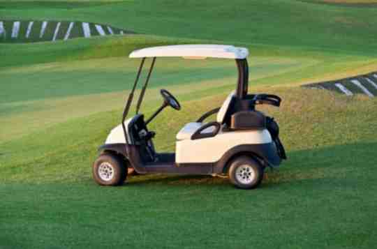 Eco-friendly golf cart shuttle on a green landscape, offering convenient and sustainable transportation within the DLF The Dahlias community in Gurgaon.